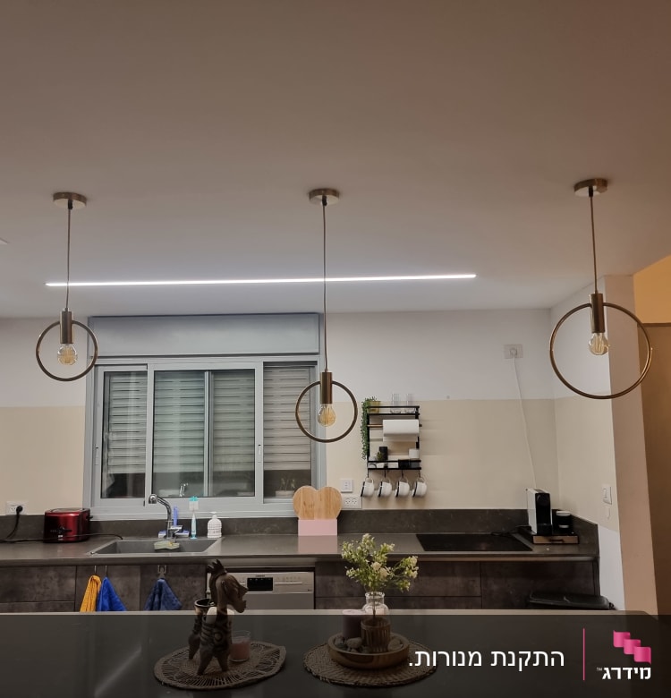 שלושה גופי תאורה תלויים עם נורות חשמליות